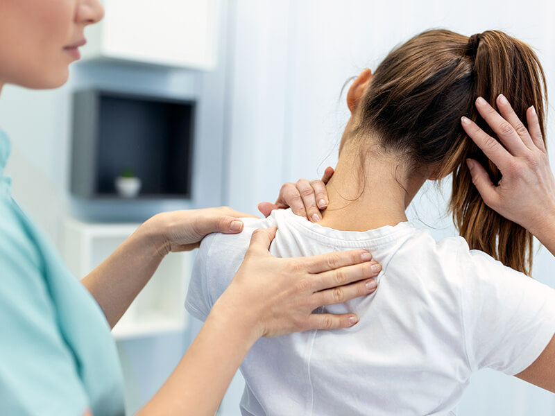 Therapeutin bei einer Ăśbung am RĂĽcken der Patientin.
