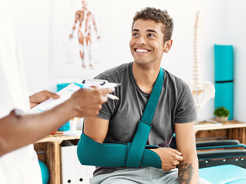 Patient bei einem GesprÀch aufgrund seiner Verlertzung am Arm. Dabei trÀgt Er am rechten Arm eine Schiene.